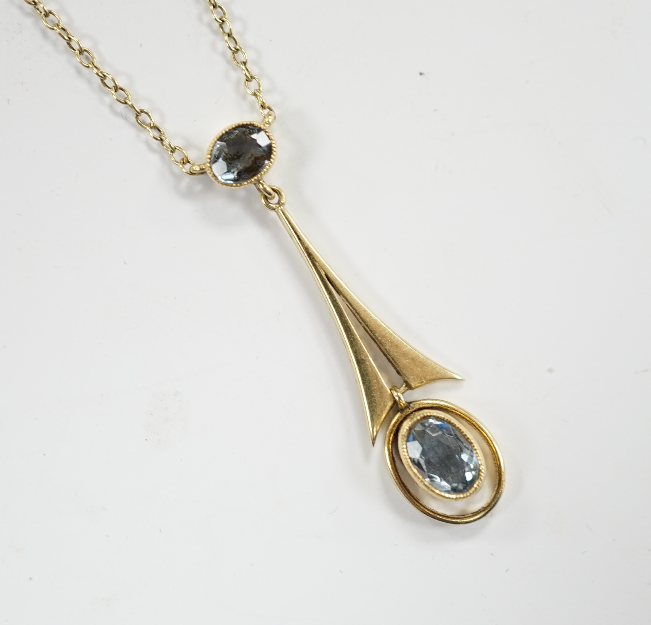 An Edwardian Art Nouveau 15ct and two stone aquamarine set drop pendant necklace, overall 43cm, gross weight 2.9 grams.